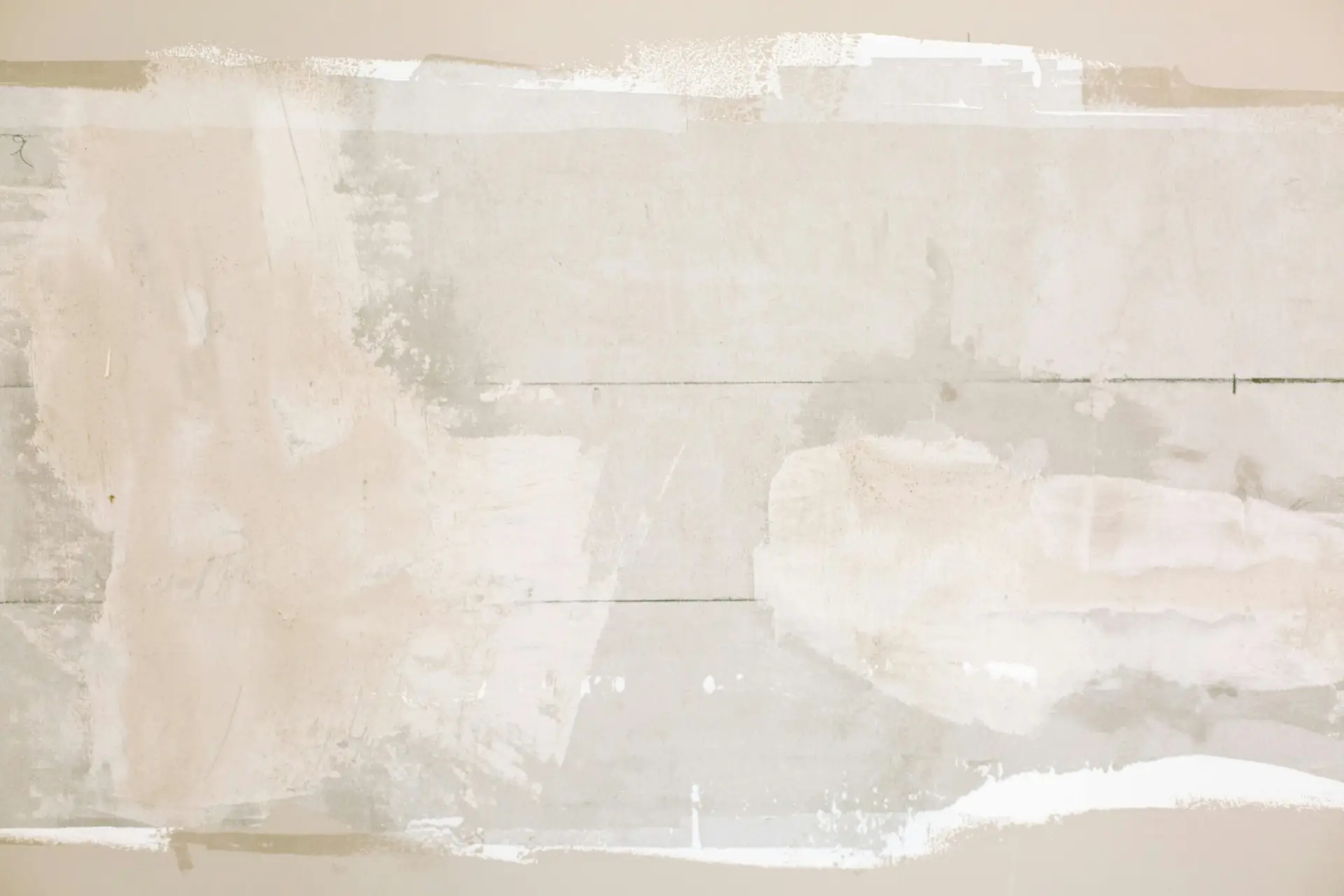 Close-up of an unfinished wall showing plaster and paint textures in a home renovation.